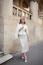 a lady wears a silk midi skirt with a suit vest and blazer